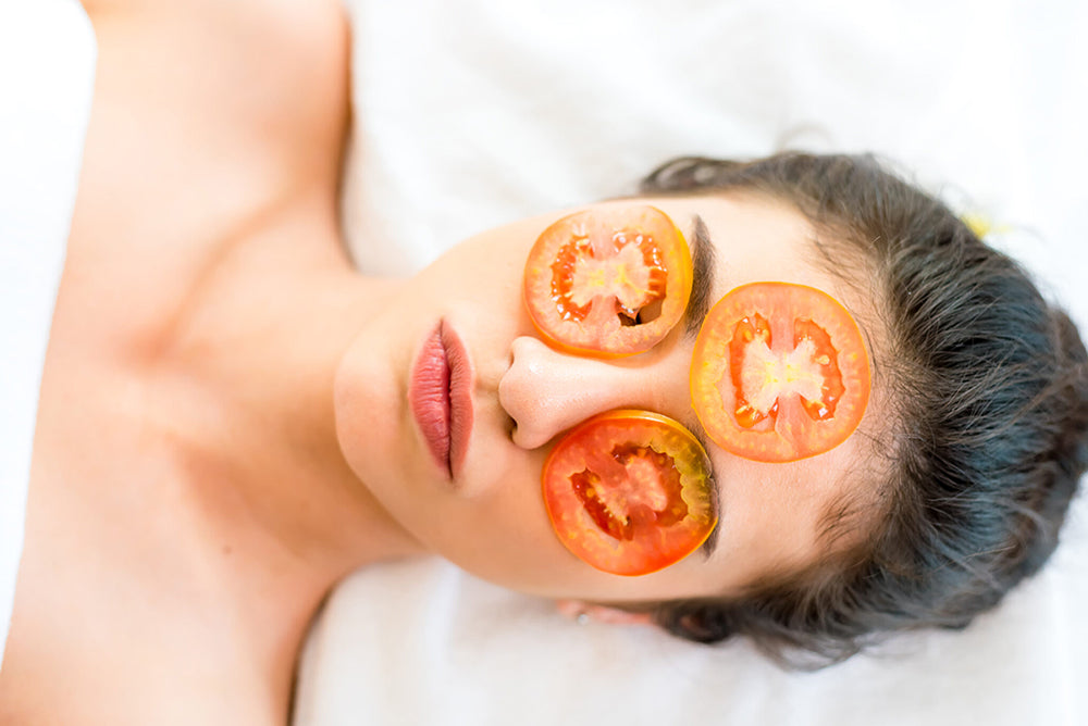 Woman with tomatoes over her face to protect her skin